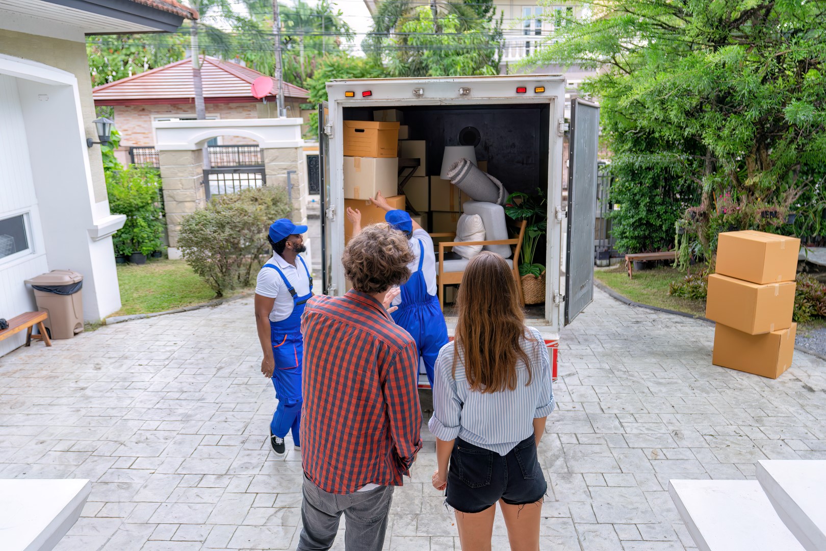 couple watching movers load a truck
